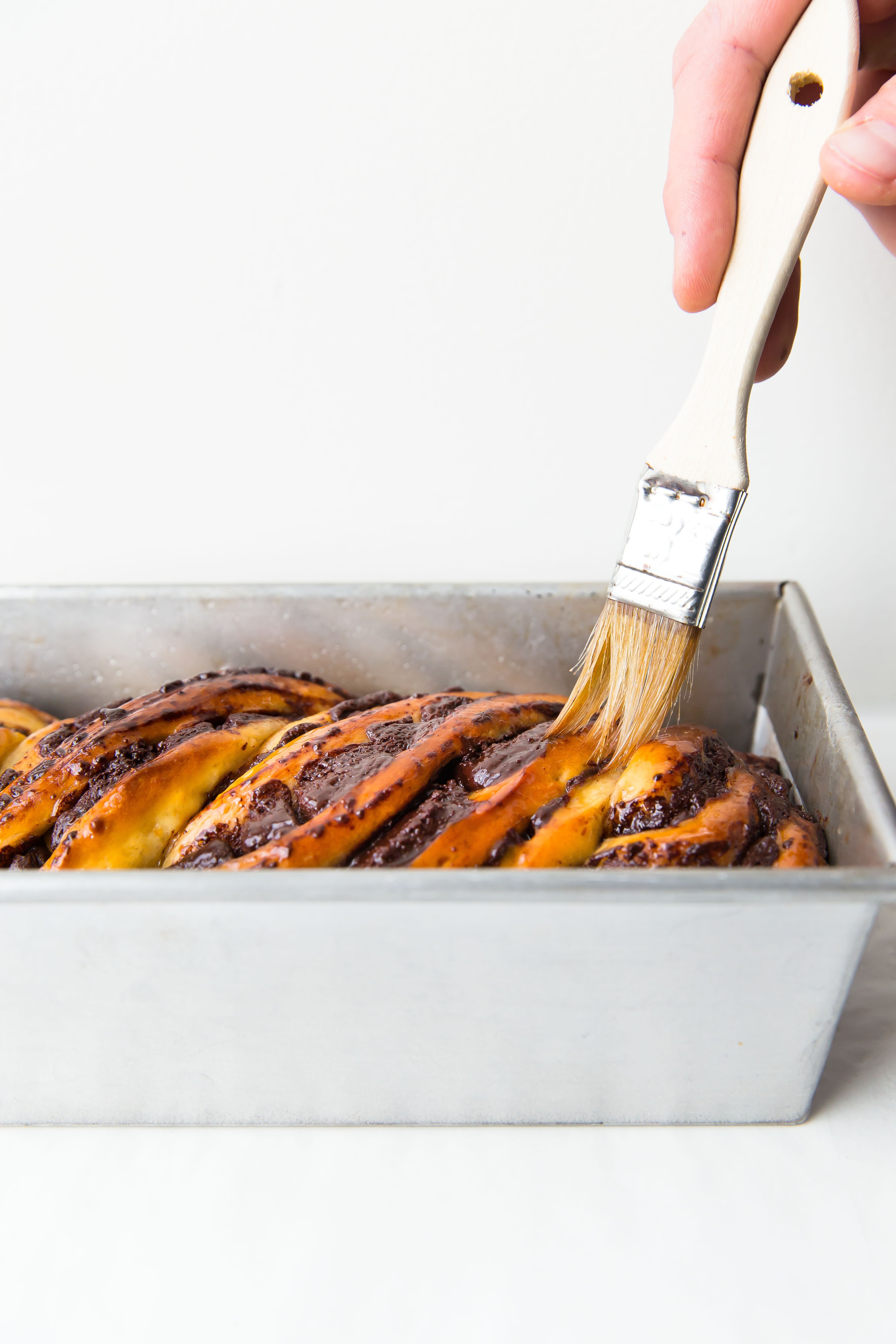 brushing syrup onto chocolate babka