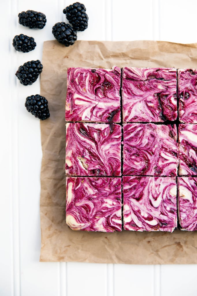 Blackberry cheesecake brownies sliced on parchment paper