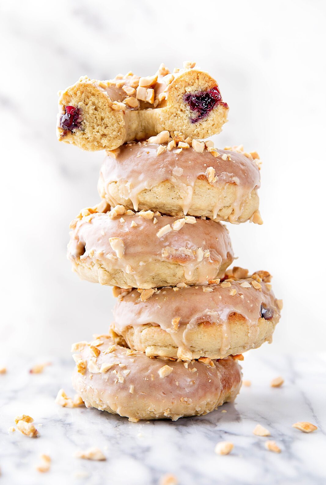 Your childhood favorite just got a makeover: Peanut Butter and Jelly Donuts stuffed with jelly and topped with peanut butter glaze and chopped peanuts!