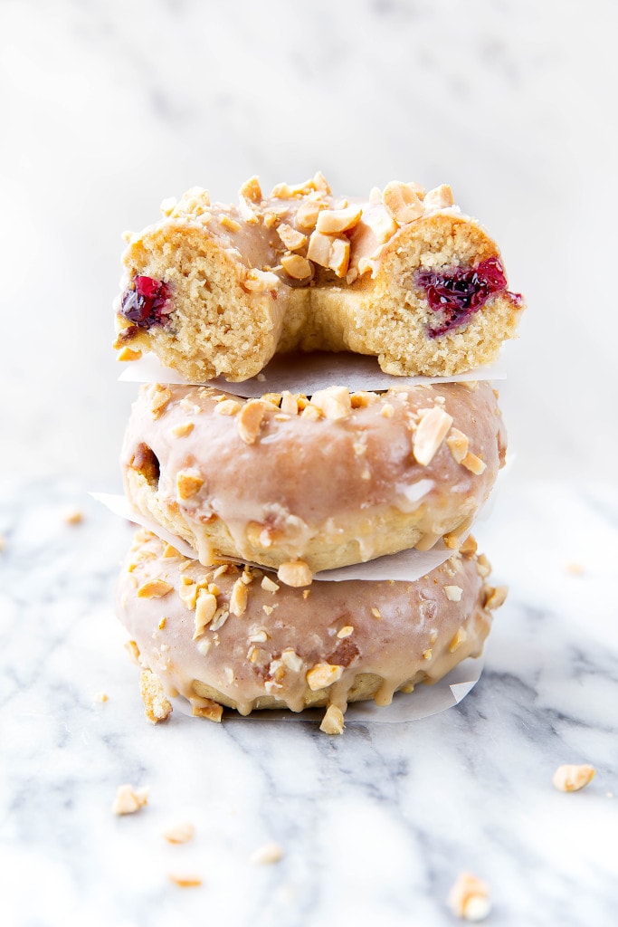 Your childhood favorite just got a makeover: Peanut Butter and Jelly Donuts stuffed with jelly and topped with peanut butter glaze and chopped peanuts!