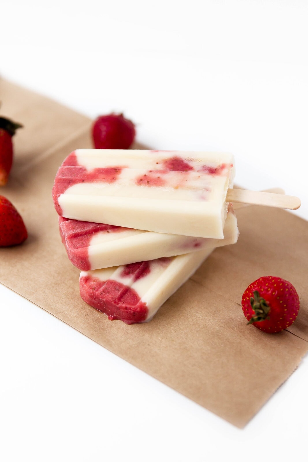 Skinny Strawberries and Cream Popsicles: layers of roasted strawberries and greek yogurt make these popsicles a bikini-welcome summer treat!