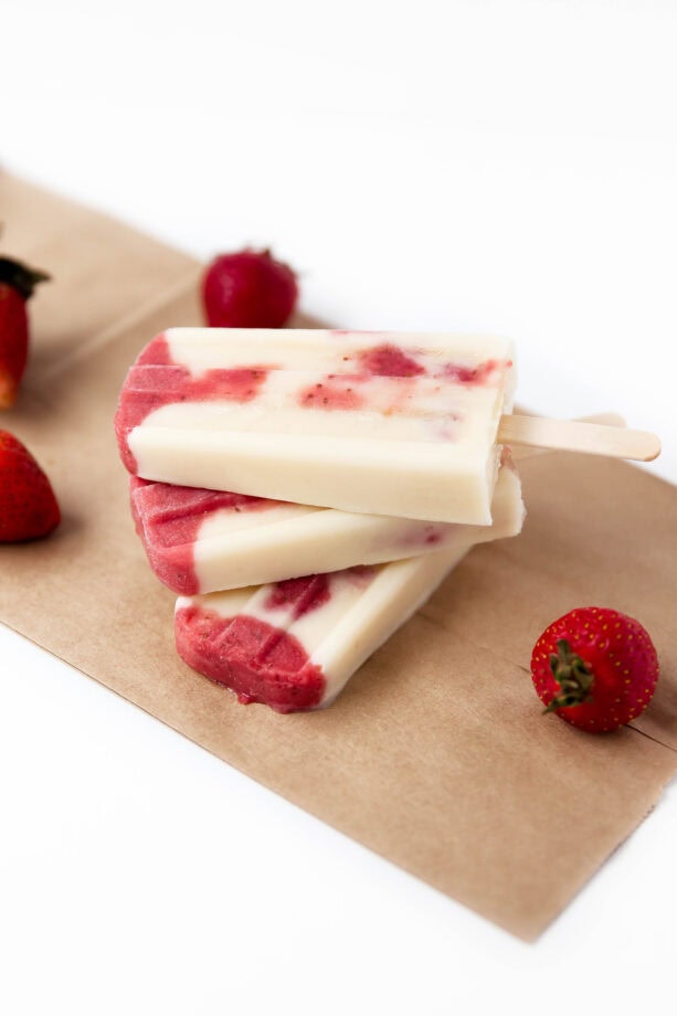 Skinny Strawberries and Cream Popsicles: layers of roasted strawberries and greek yogurt make these popsicles a bikini-welcome summer treat!