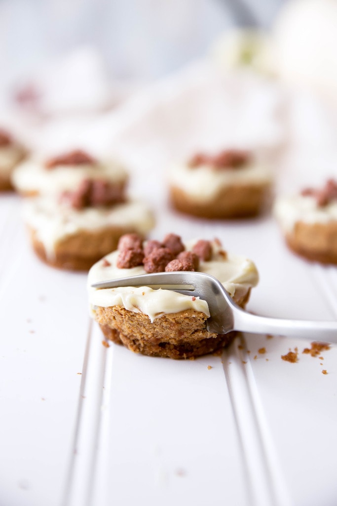 Mini pumpkin spice cheesecakes topped with a white chocolate ganache and cinnamon candied peanuts!