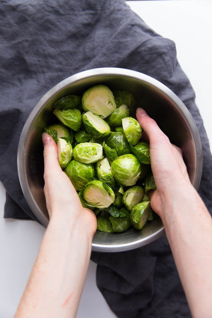 Oven roasted brussels sprouts with a blueberry balsamic glaze tossed with bacon and blue cheese makes for a delectable addition to your holiday table!