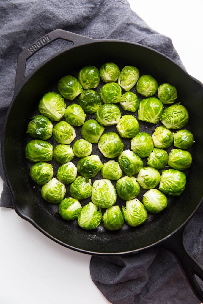 Oven roasted brussels sprouts with a blueberry balsamic glaze tossed with bacon and blue cheese makes for a delectable addition to your holiday table!