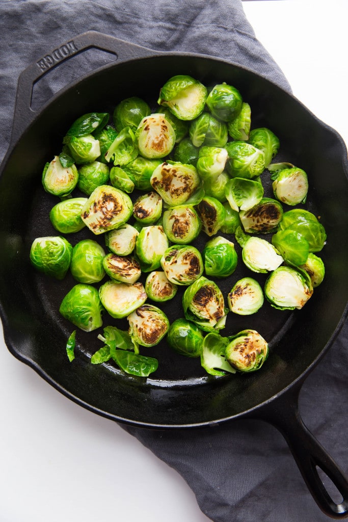 Oven roasted brussels sprouts with a blueberry balsamic glaze tossed with bacon and blue cheese makes for a delectable addition to your holiday table!