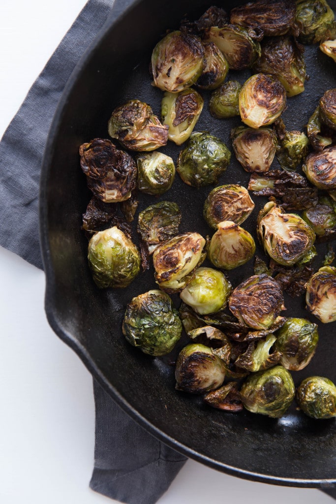 Oven roasted brussels sprouts with a blueberry balsamic glaze tossed with bacon and blue cheese makes for a delectable addition to your holiday table!