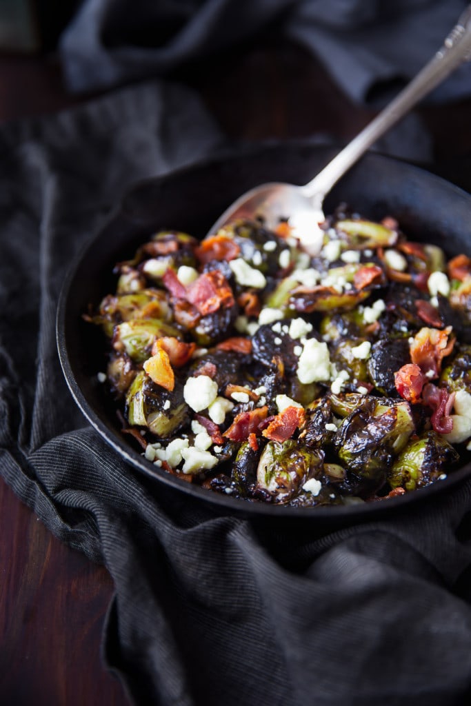 Oven roasted brussels sprouts with a blueberry balsamic glaze tossed with bacon and blue cheese makes for a delectable addition to your holiday table!