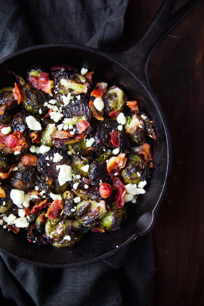 Oven roasted brussels sprouts with a blueberry balsamic glaze tossed with bacon and blue cheese makes for a delectable addition to your holiday table!