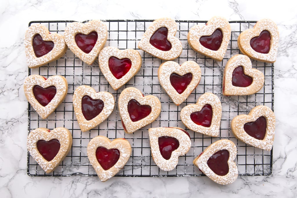 cherry linzer cookies on a wire cooling rack