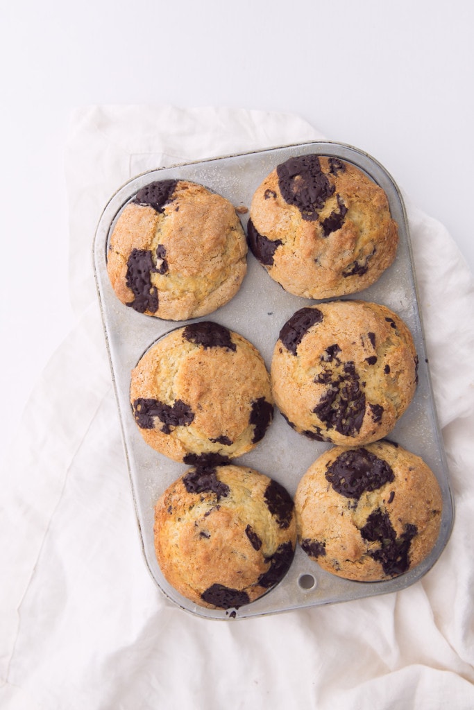 chocolate chunk muffins in muffin tin on towel