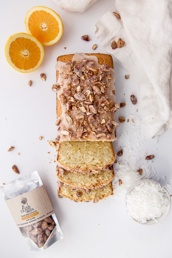 A tropical coconut orange bread topped with coconut glaze and candied coconut orange almonds!