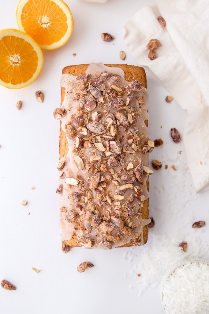 A tropical coconut orange bread topped with coconut glaze and candied coconut orange almonds!