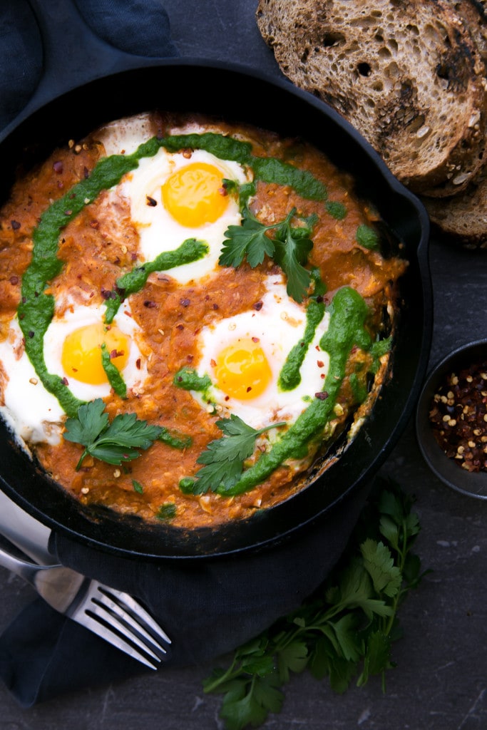 shakshuka (eggs in hell) in a cast iron skillet with bread slices
