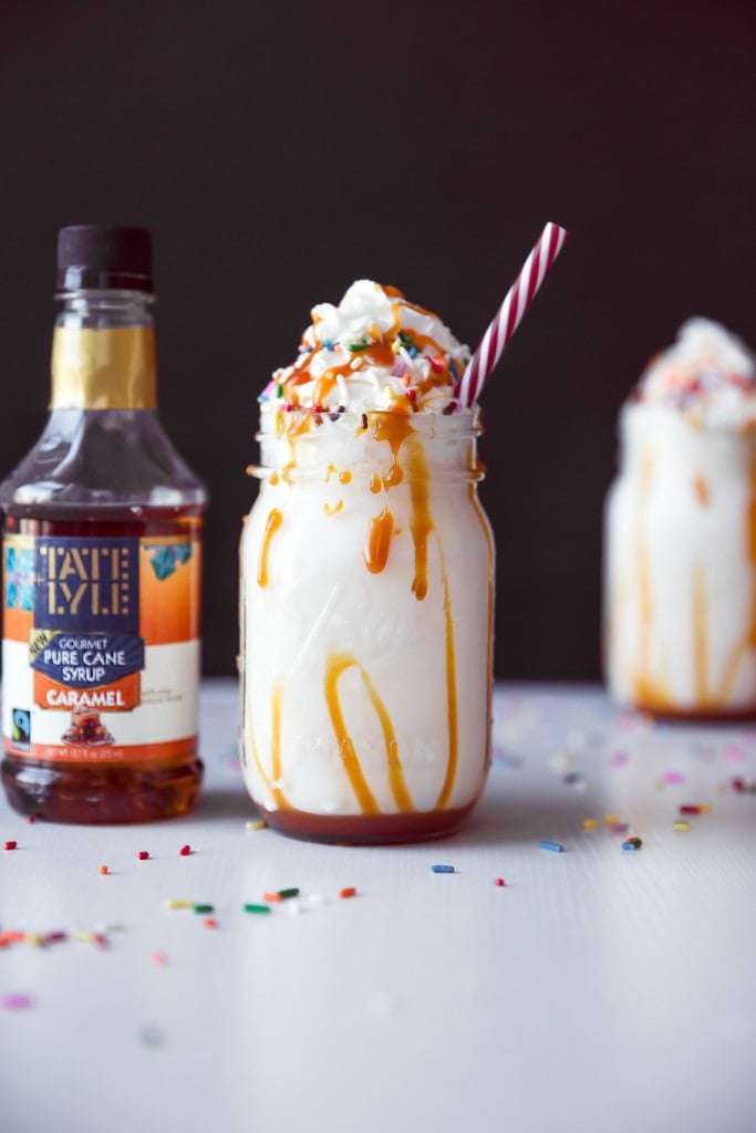 caramel milkshake next to a bottle of caramel syrup