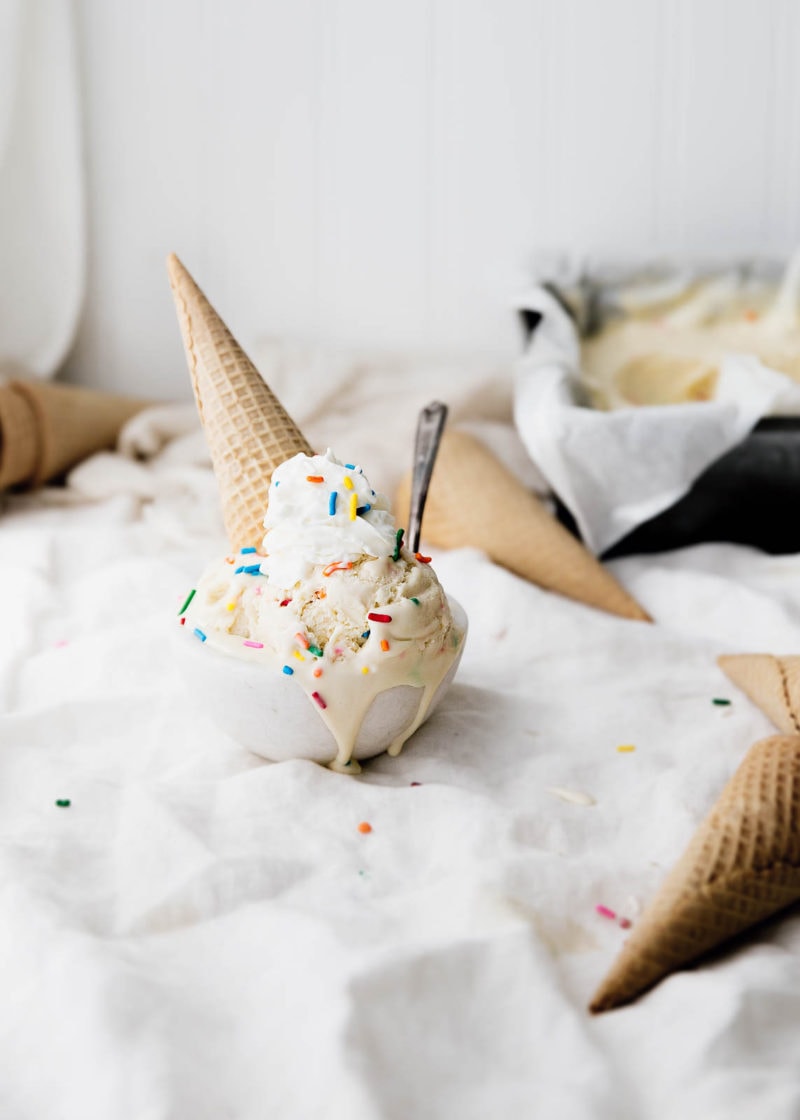 Cake Batter Ice Cream in a bowl with sprinkles and an ice cream cone