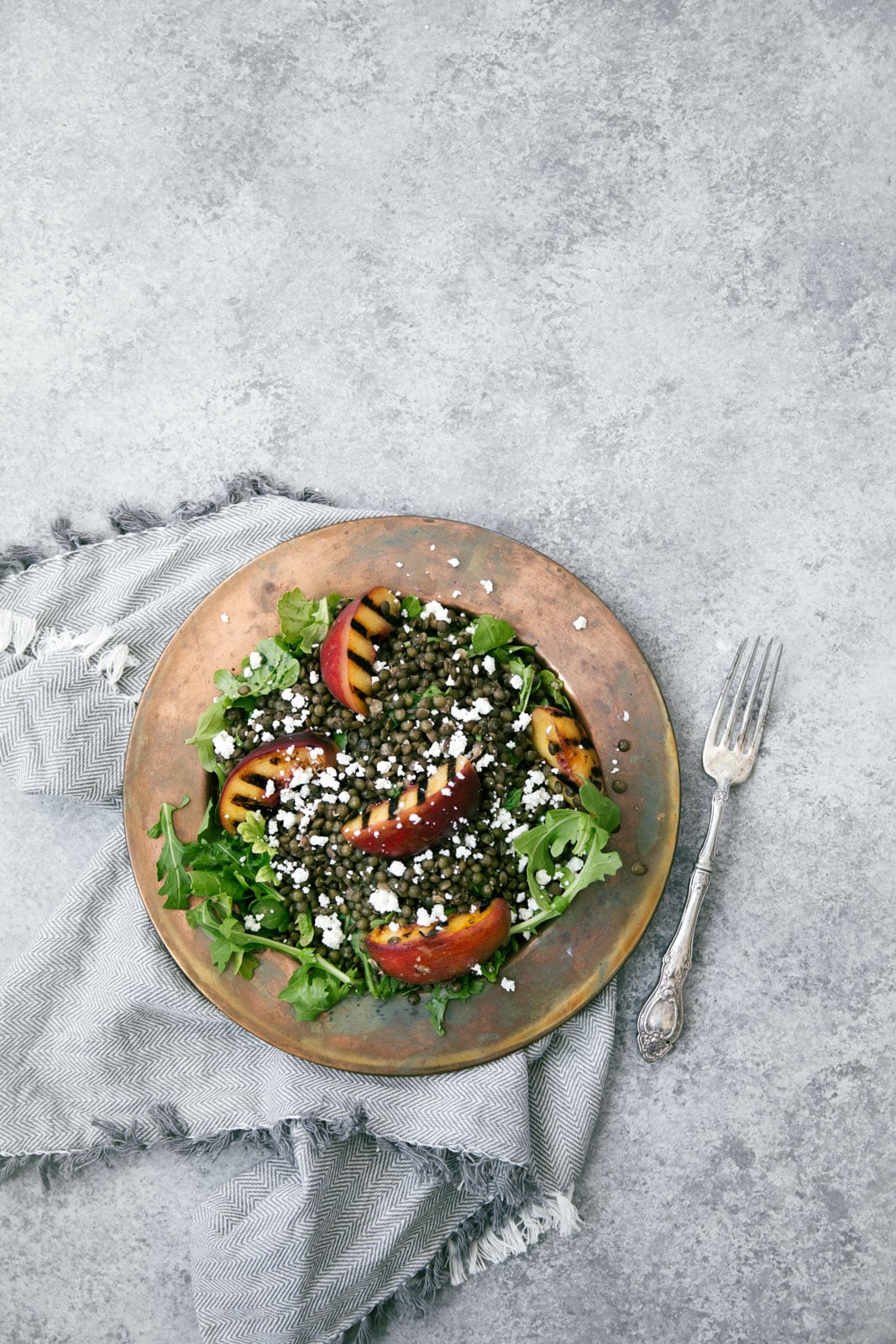 Take advantage of peach season with this green lentil salad with char-grilled peaches, goat cheese, and rosé vinaigrette.