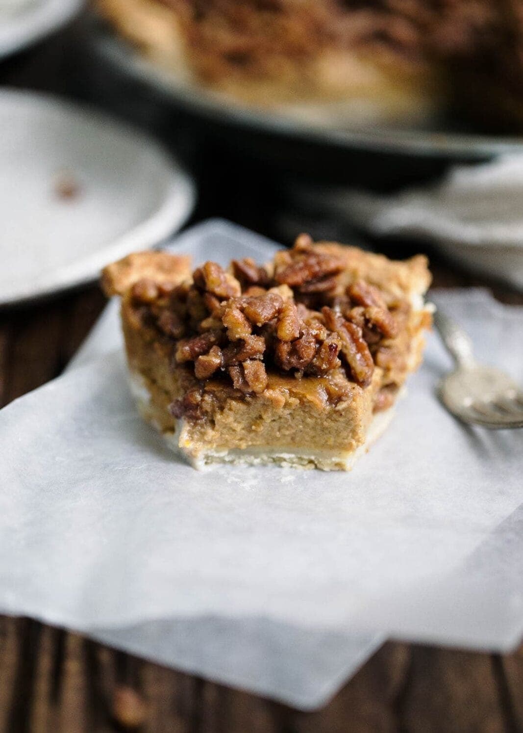 Maple pecans meet a boozy bourbon pumpkin filling in this maple bourbon pecan pumpkin pie worthy of any Thanksgiving dessert table.