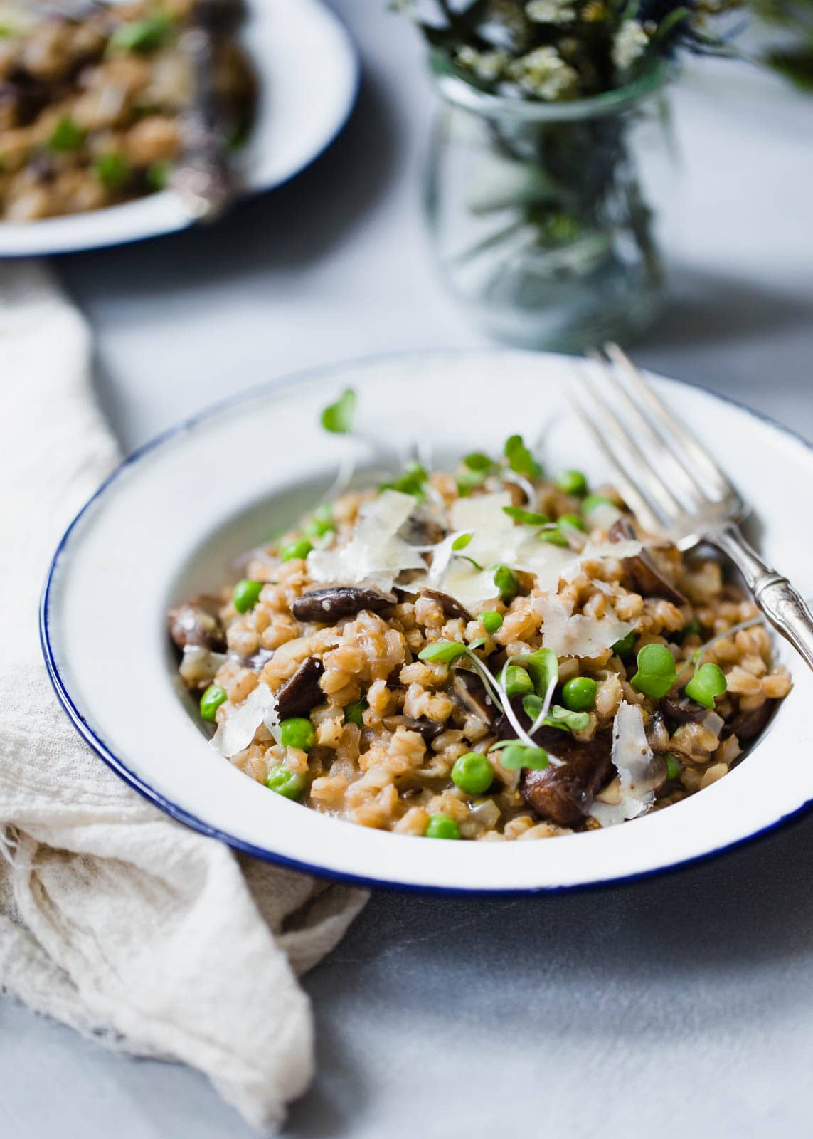 A warm and comforting farro risotto made with fresh spring peas and sautéed mushrooms!