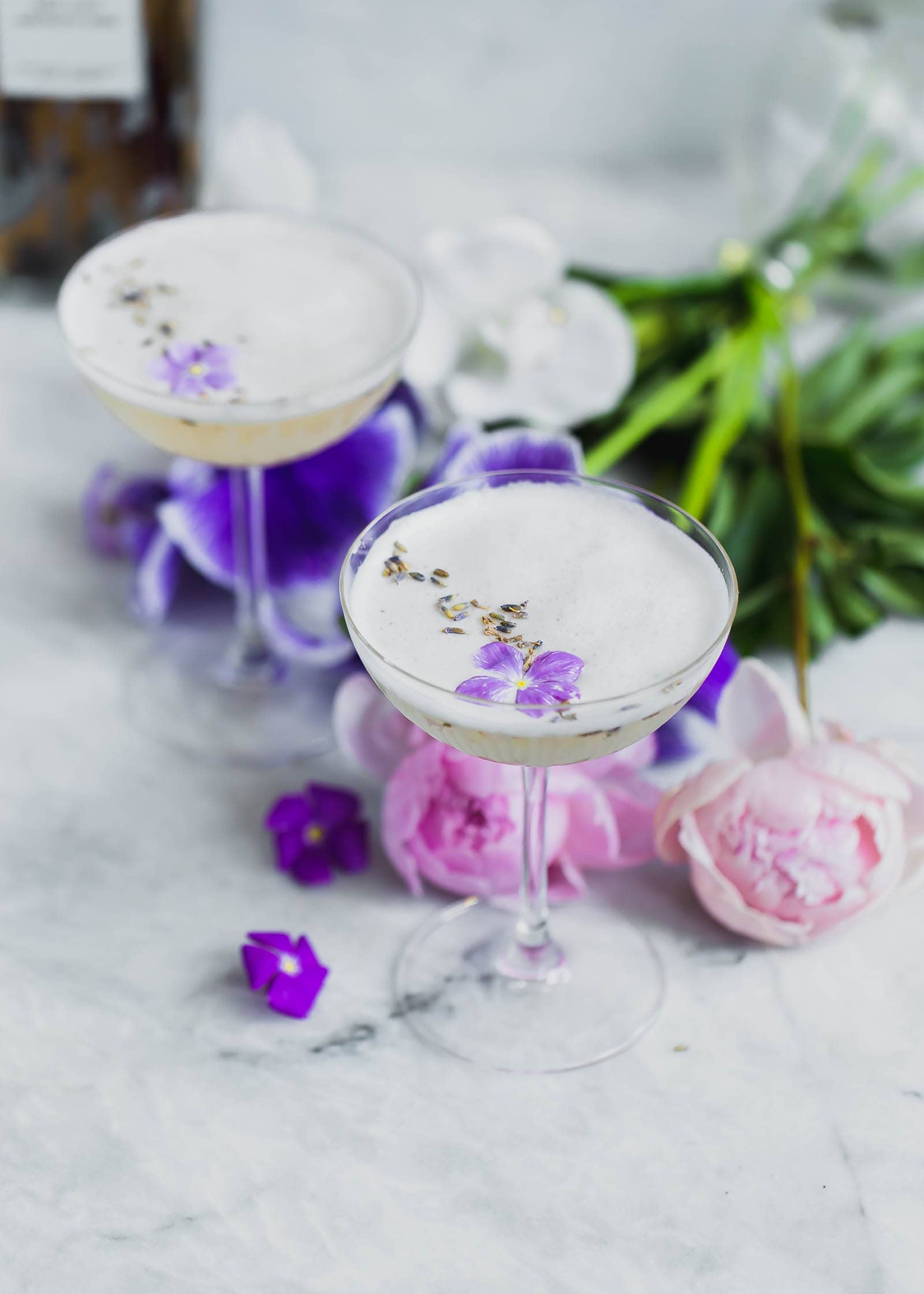 Lavender Coconut Vodka Sours topped with violets