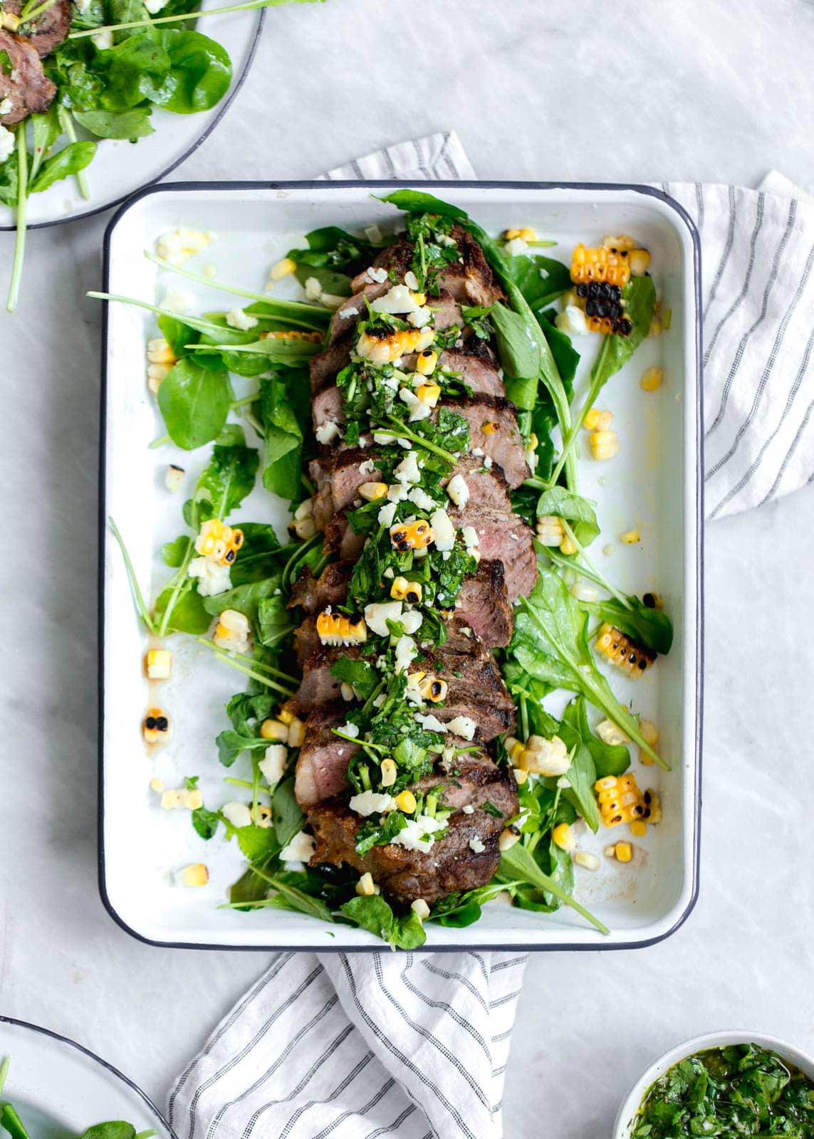 An epic Chimichurri Steak Salad with charred corn, cotija cheese, arugula, and a homemade chimichurri sauce. Perfect for summer nights!