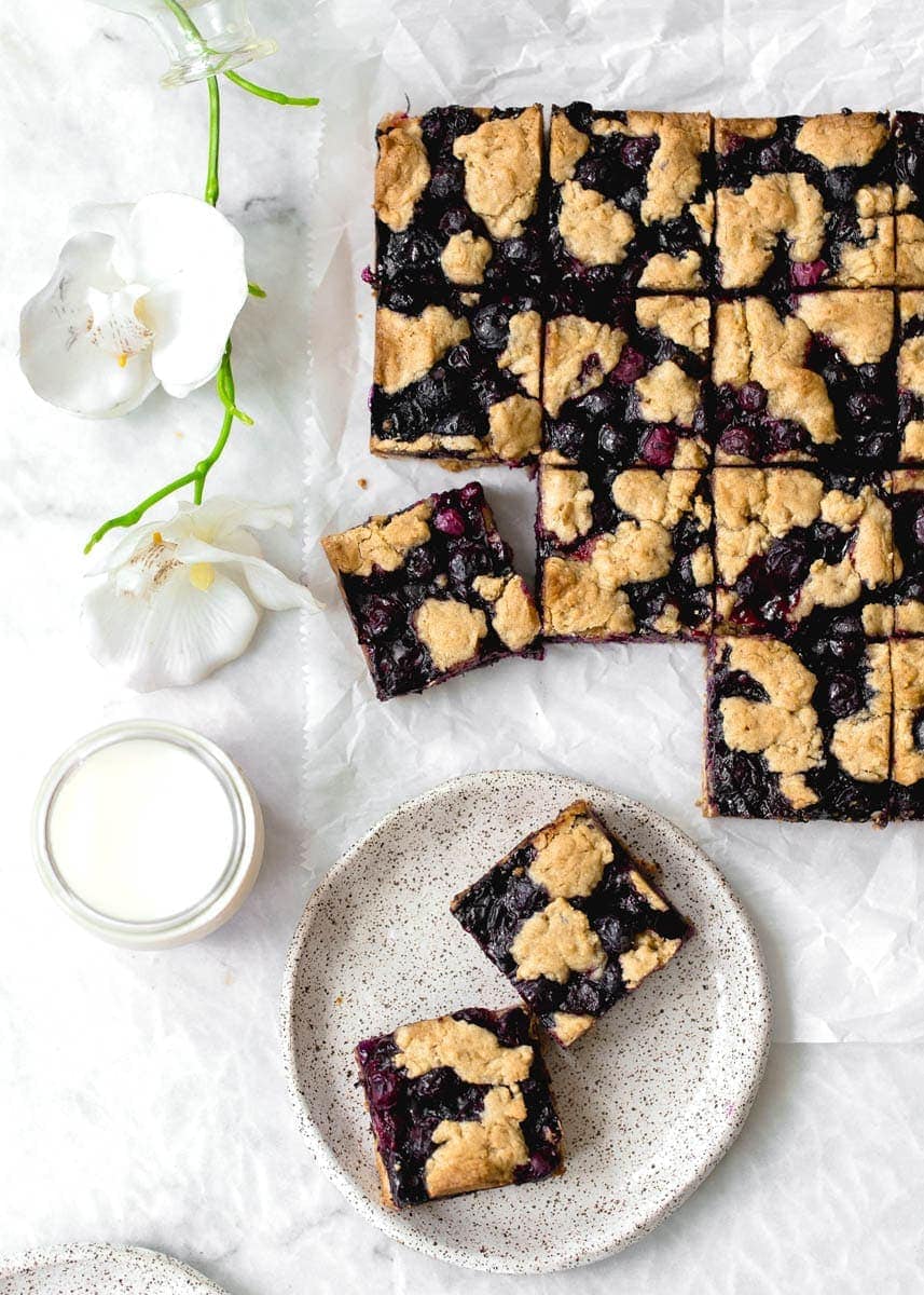 Whole Wheat Ginger Blueberry Crumble Bars with fresh blueberries. Perfect with a glass of cold milk.