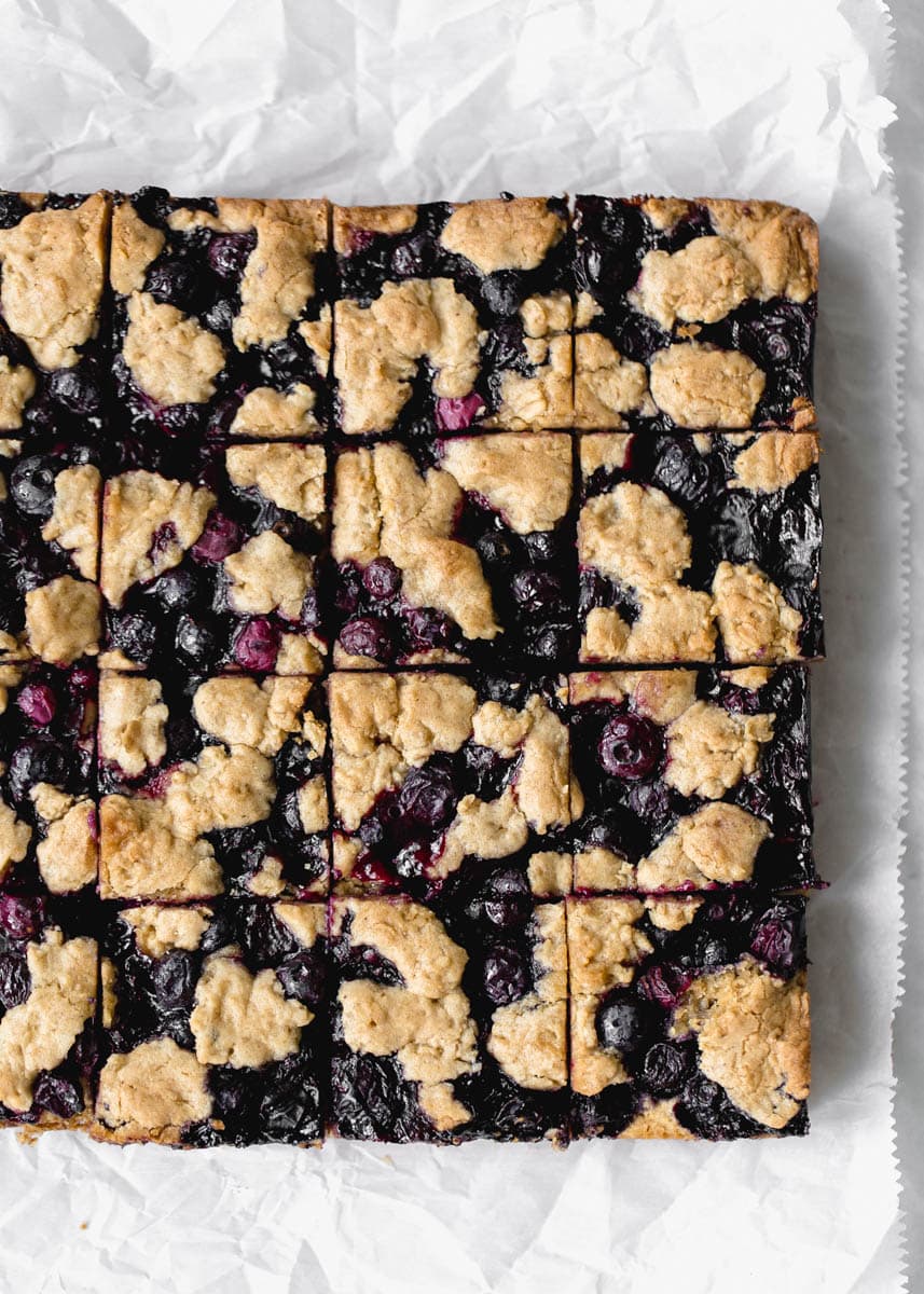 Whole Wheat Ginger Blueberry Crumble Bars with fresh blueberries. Perfect with a glass of cold milk.