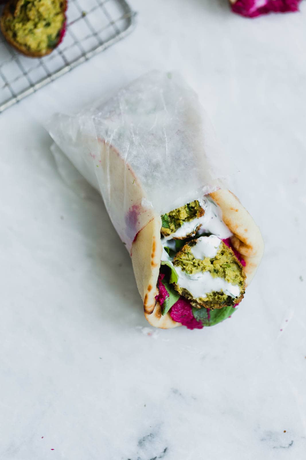 green falafel sandwich in wax paper