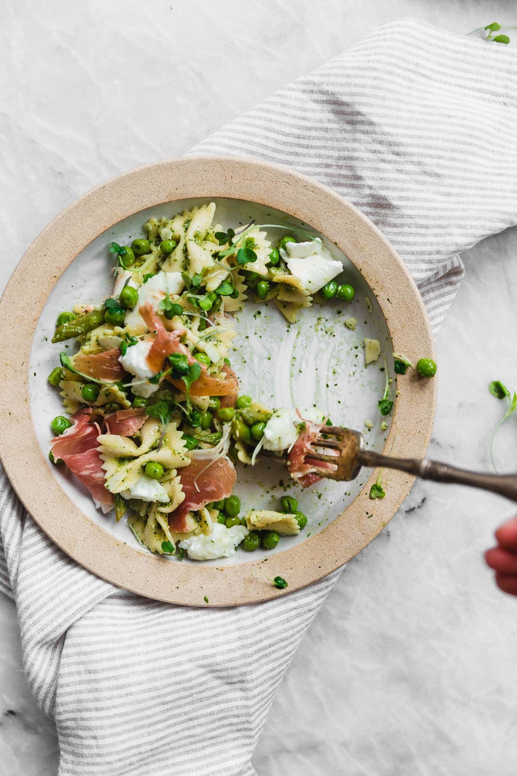 A sensational pasta salad with homemade pesto, prosciutto, peas, asparagus, and burrata.