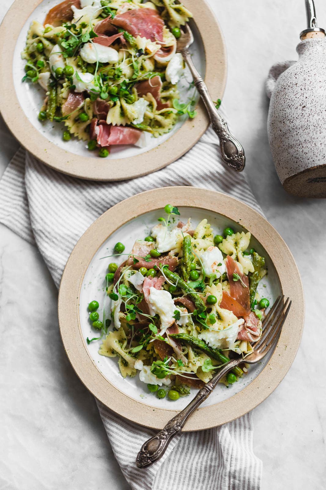 A sensational pasta salad with homemade pesto, prosciutto, peas, asparagus, and burrata.