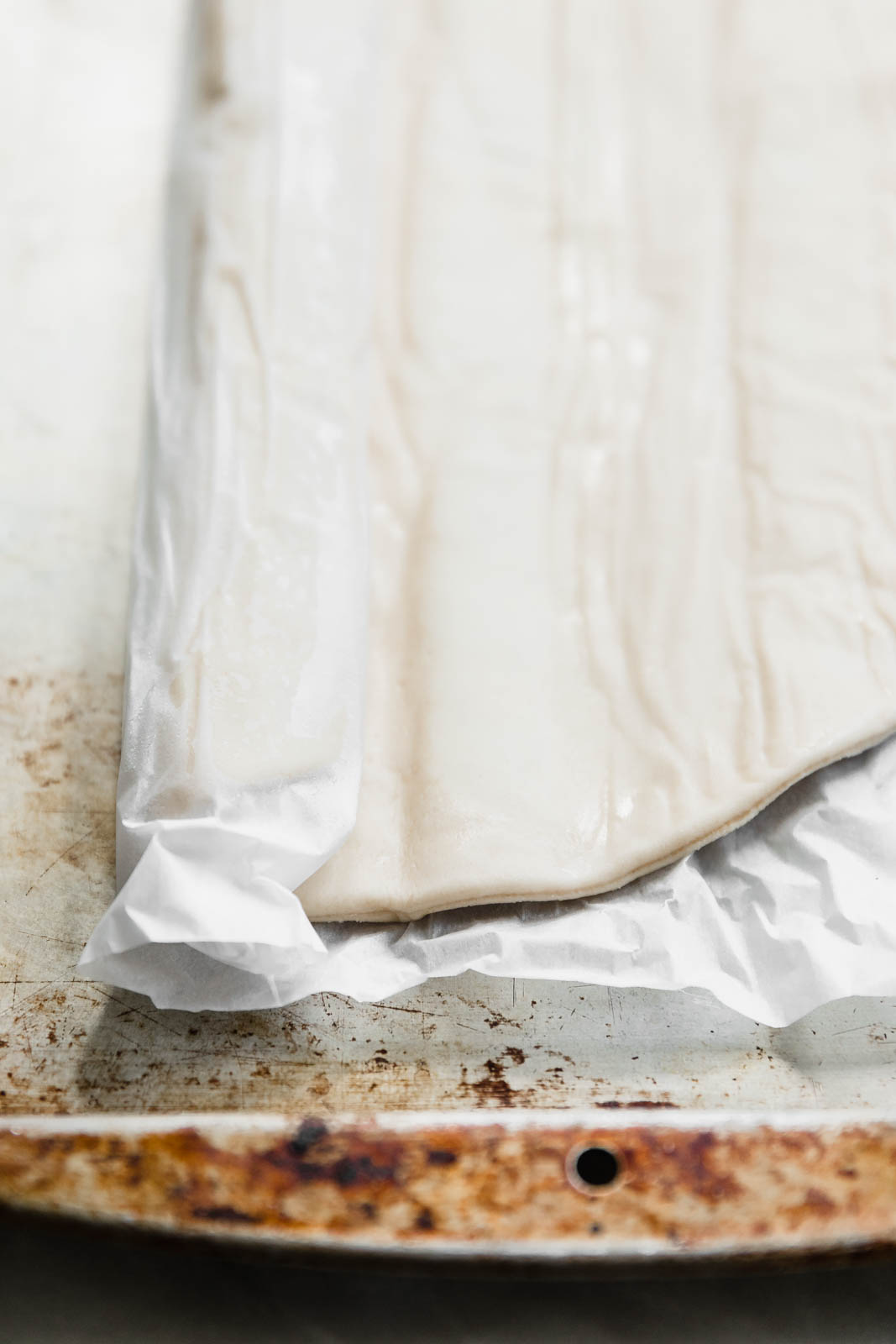 raw pizza dough on a baking sheet