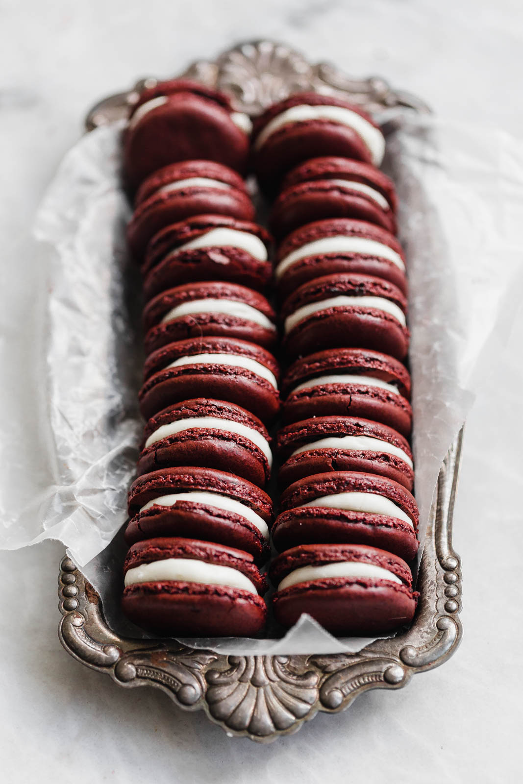 Decadent Red Velvet Macarons with a cream cheese frosting. Perfect for the holiday season, or just because!