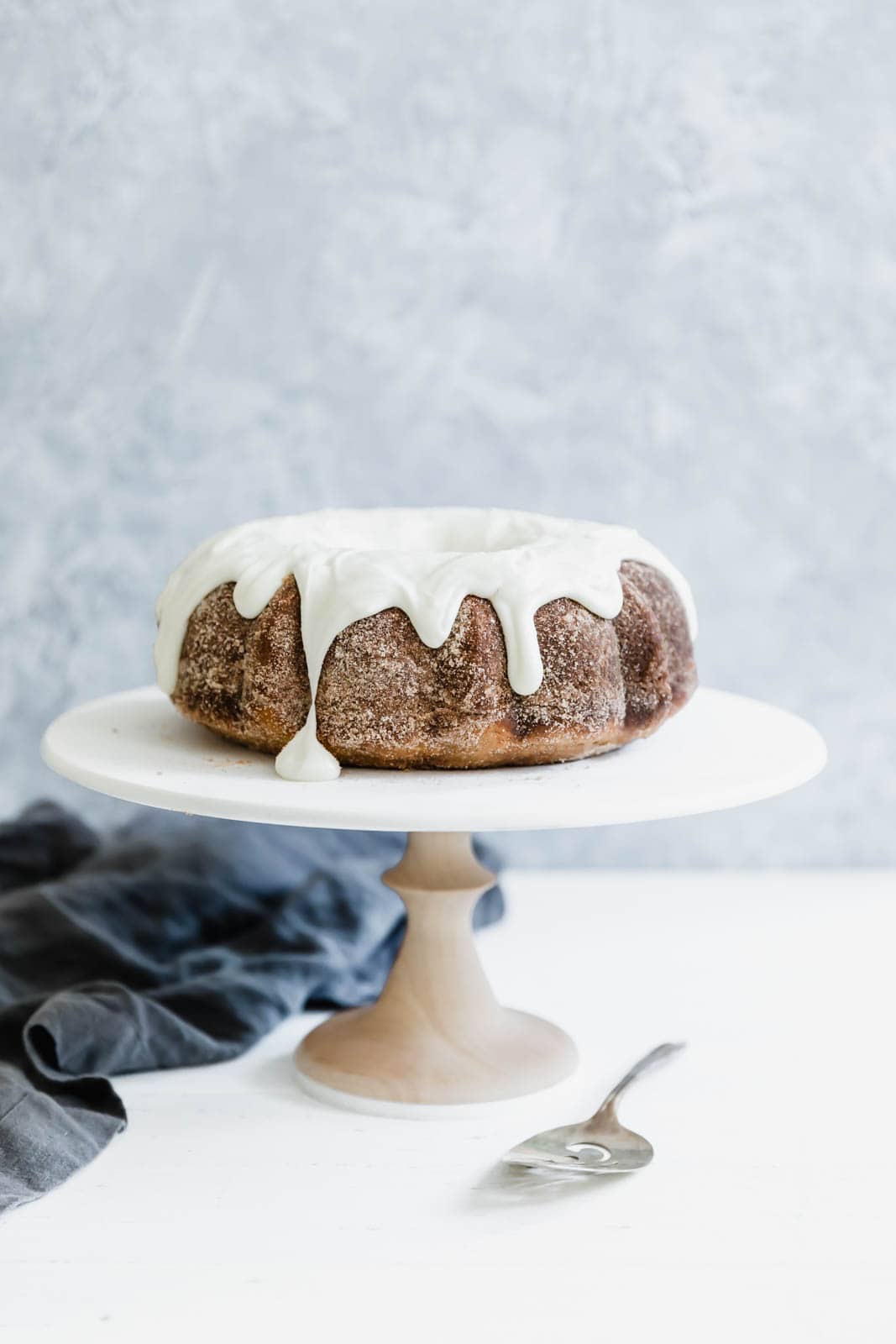 Cinnamon Bundt Cake on cake stand with spatula