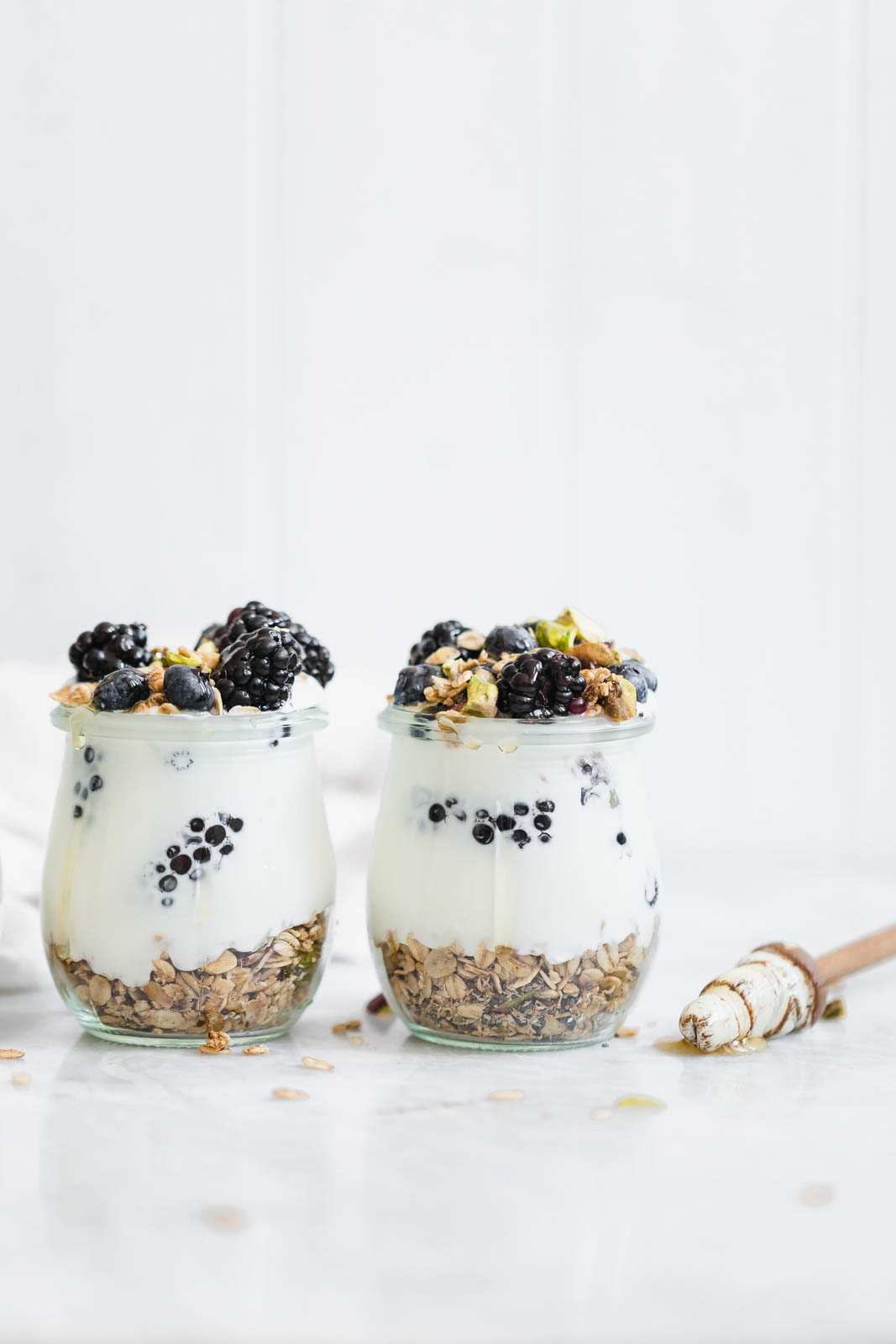 A chai-spiced Cardamom Granola Parfait made with the most addicting Cardamom granola, and topped with blackberries and honey.
