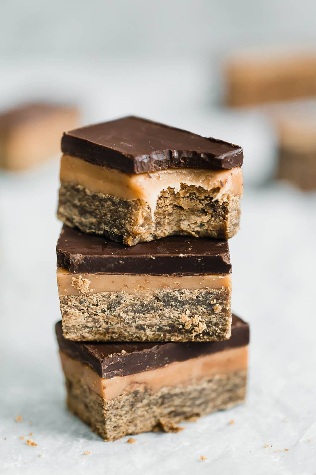 Classic Millionaire Bars get a twist with these Gingerbread Millionaire Bars! Made with spiced ginger shortbread, homemade chewy caramel, and chocolate!