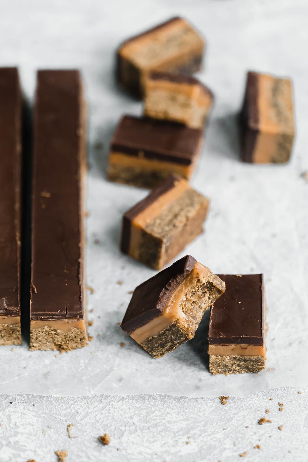 Classic Millionaire Bars get a twist with these Gingerbread Millionaire Bars! Made with spiced ginger shortbread, homemade chewy caramel, and chocolate!