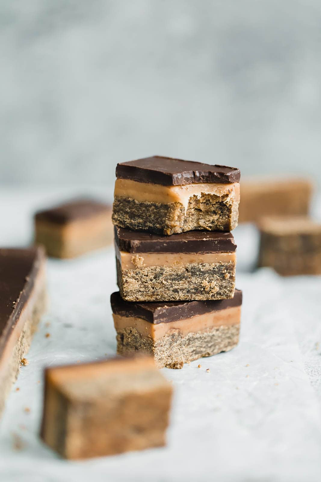 Classic Millionaire Bars get a twist with these Gingerbread Millionaire Bars! Made with spiced ginger shortbread, homemade chewy caramel, and chocolate!