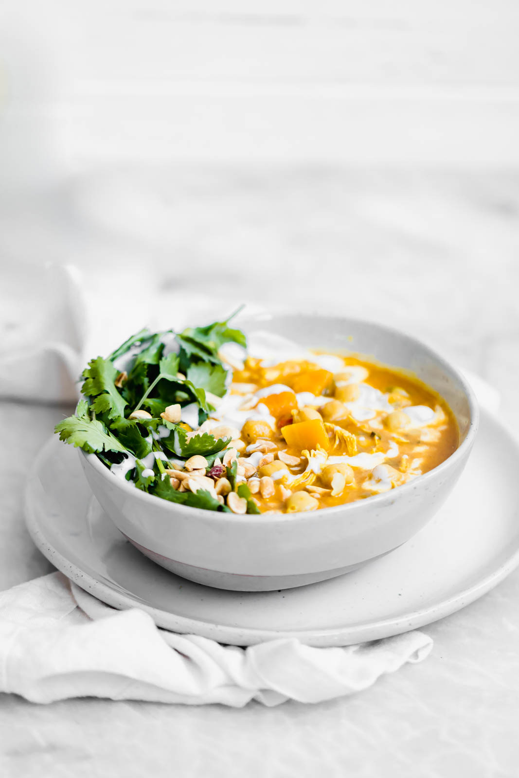 Turmeric Chicken Soup garnished with peanuts and cilantro