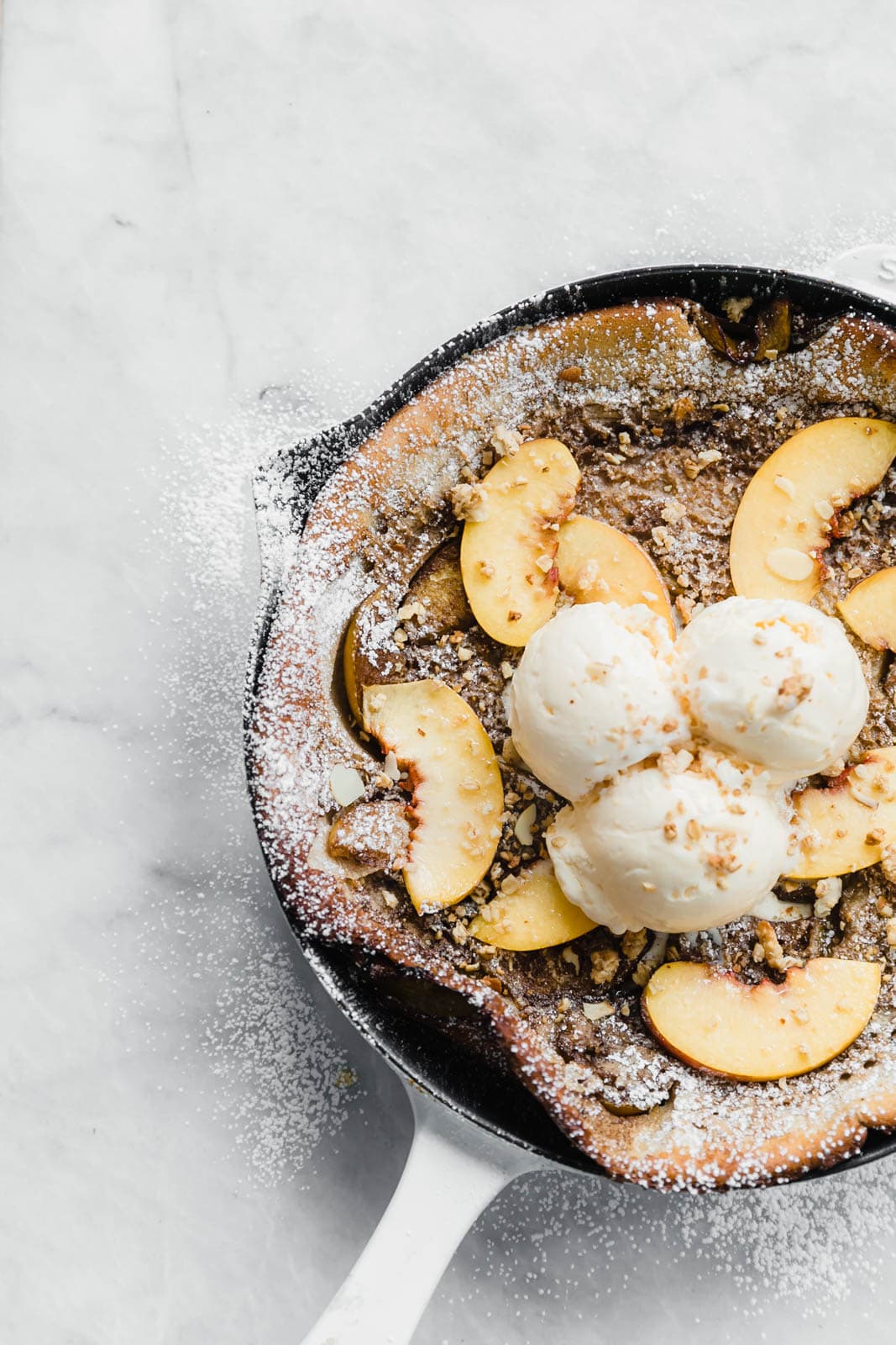 A deliciously epic bourbon brown butter peach dutch baby topped with granola, fresh peaches, and vanilla ice cream! Perfect for a lazy Sunday morning :)