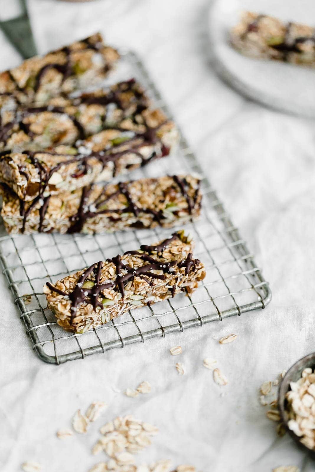 Raw Seedy Granola Bars made with oats, sunflower seeds, pepitas, sesame seeds, almonds, apricots, and honey, topped with a drizzle of dark chocolate