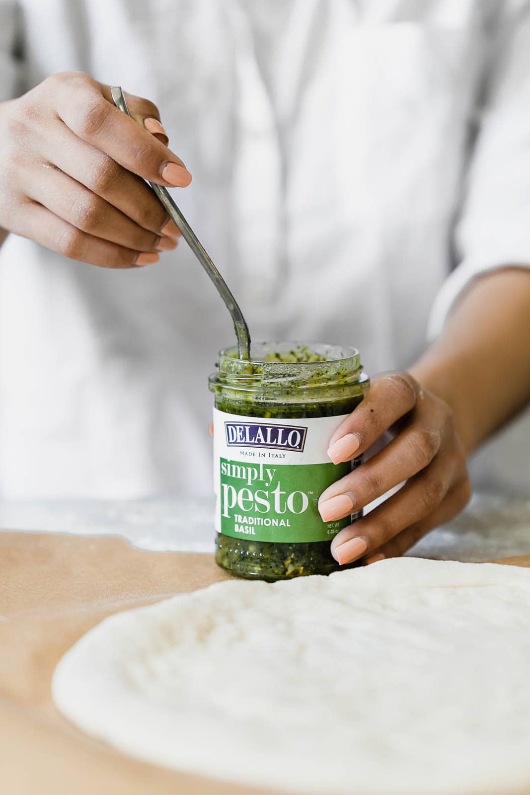 A Spring Green Goddess Pizza made with pesto, zucchini, spring peas, watercress, mozzarella, and a green goddess dressing.