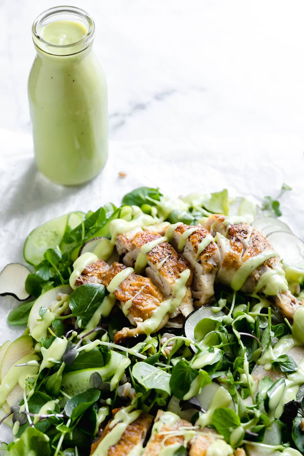 A loaded green chicken salad with watercress, green apples, farro, and a "creamy" dairy-free avocado dressing! So perfect for summer entertaining.