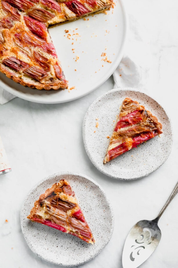The most showstopping Rhubarb Bakewell Tart made with a pâte sucrée crust, strawberry preserves, almond frangipane, and an orange-soaked rhubarb top