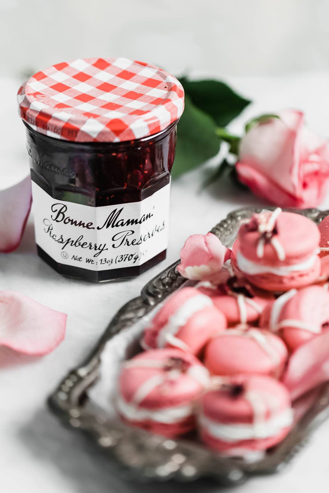 Raspberry Rose Macarons made with rosewater, a vanilla buttercream, and a surprise raspberry preserve center. Simple, elegant, and oh so delicious!! 