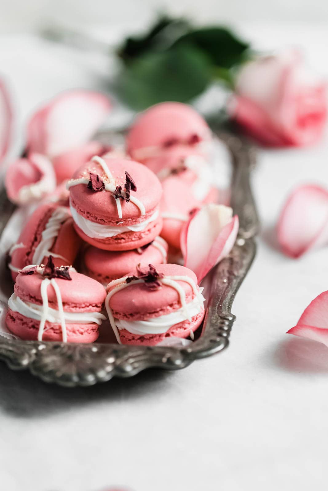 Raspberry Rose Macarons made with rosewater, a vanilla buttercream, and a surprise raspberry preserve center. Simple, elegant, and oh so delicious!! 