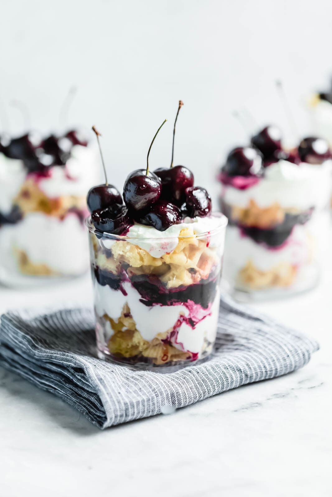 Layers of quick sautéed black cherries, fresh whipped cream, and Belgian waffles make this no-bake waffle parfait a total no-brainer summer dessert.
