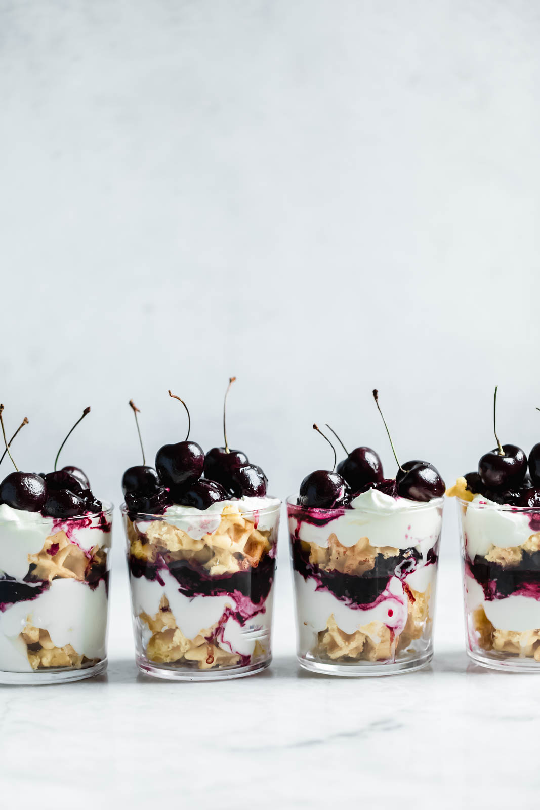 Layers of quick sautéed black cherries, fresh whipped cream, and Belgian waffles make this no-bake waffle parfait a total no-brainer summer dessert.