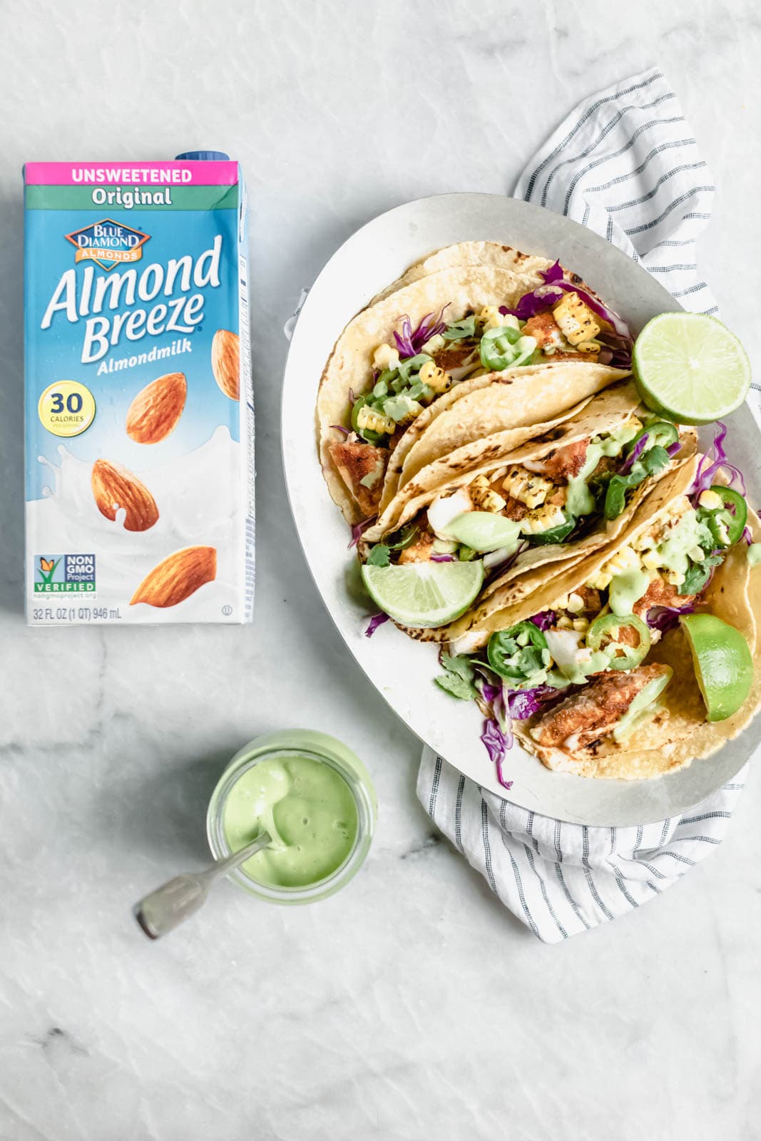 My go-to recipe for Taco Tuesday fish tacos: flakey blackened fish, cabbage, charred corn, jalapeños, and a “creamy” dairy-free avocado cilantro crema!