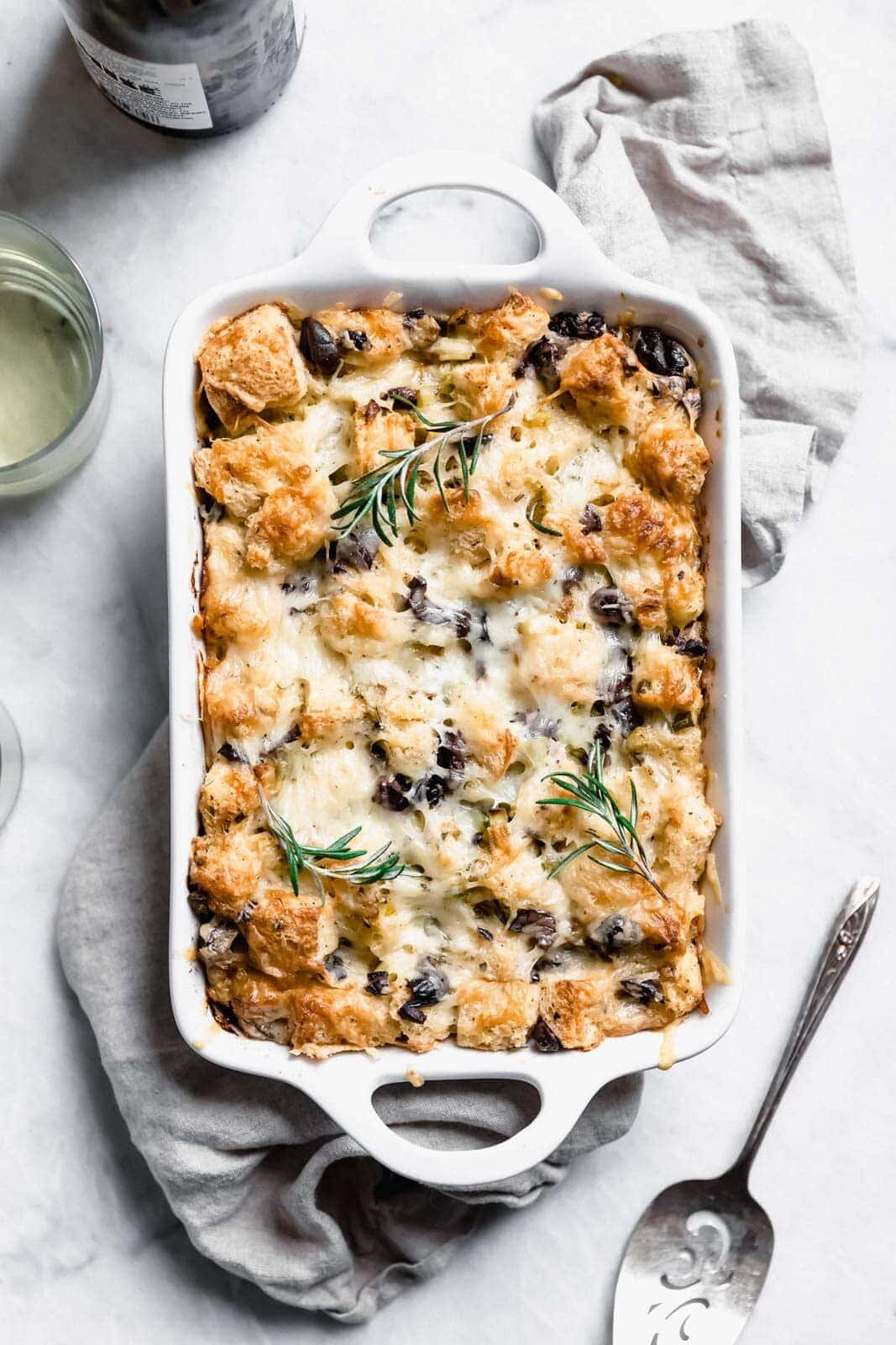 Savory Rosemary Olive Bread Pudding made with a rustic country loaf and loaded with cheesy goodness. A perfect alternative to stuffing at thanksgiving! 