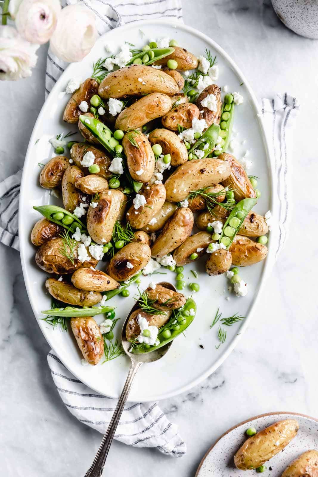 These roasted fingerling potatoes with dill, goat cheese, and peas are our new fav side dish. Full of texture and flavor, you'll love these spring potatoes.